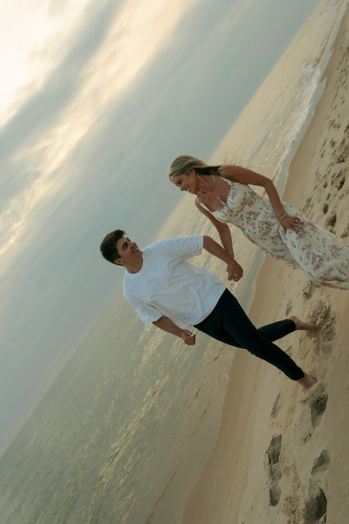 cute couple running around the beach during their session