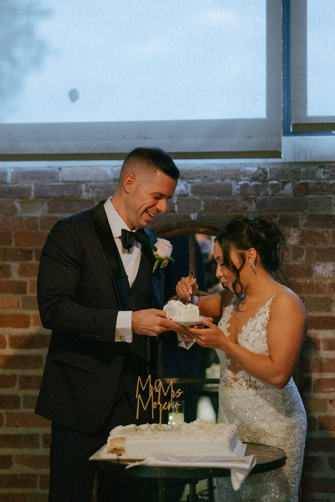 Newly married couple cutting their wedding cake