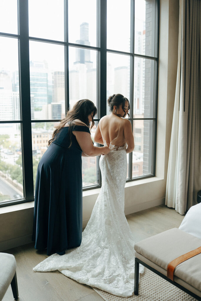 bridesmaid helping the bride with her wedding dress