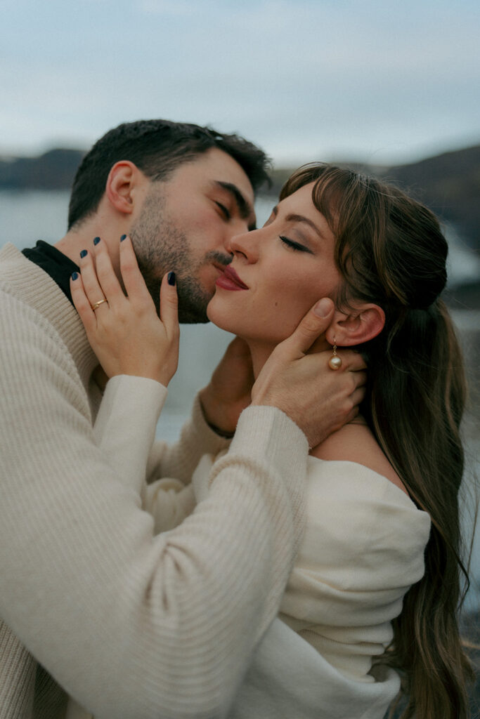 Intimate portrait of engaged couple foreheads touching on blue ice glacier in Iceland taken by destination wedding and engagement photographer from Grand Rapids