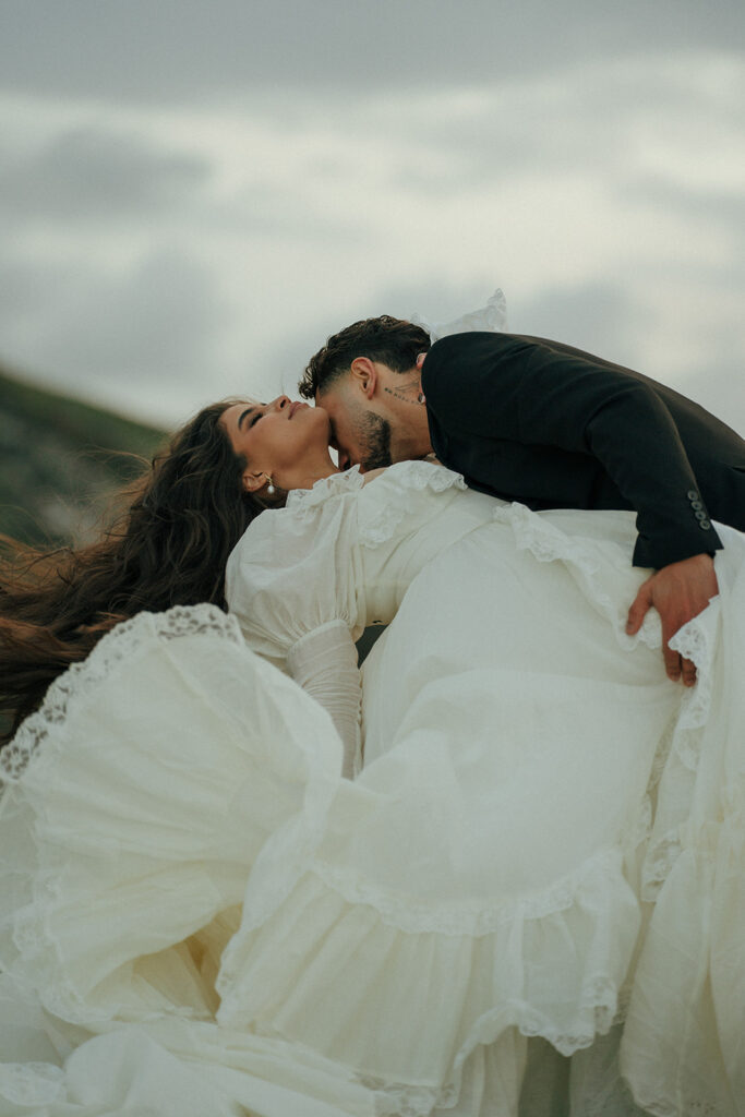 Couple kissing at sunset during cliffs elopement photos Fast Castle Edinburgh Scotland coastline