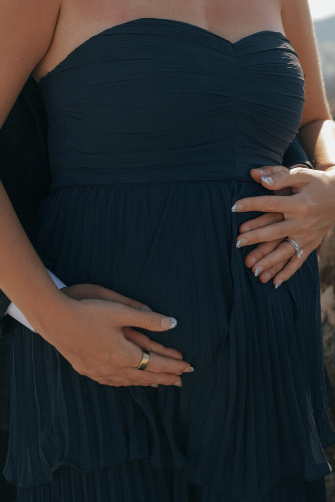 Couple holding hands walking down whitewashed steps in Oia Santorini Greece maternity session