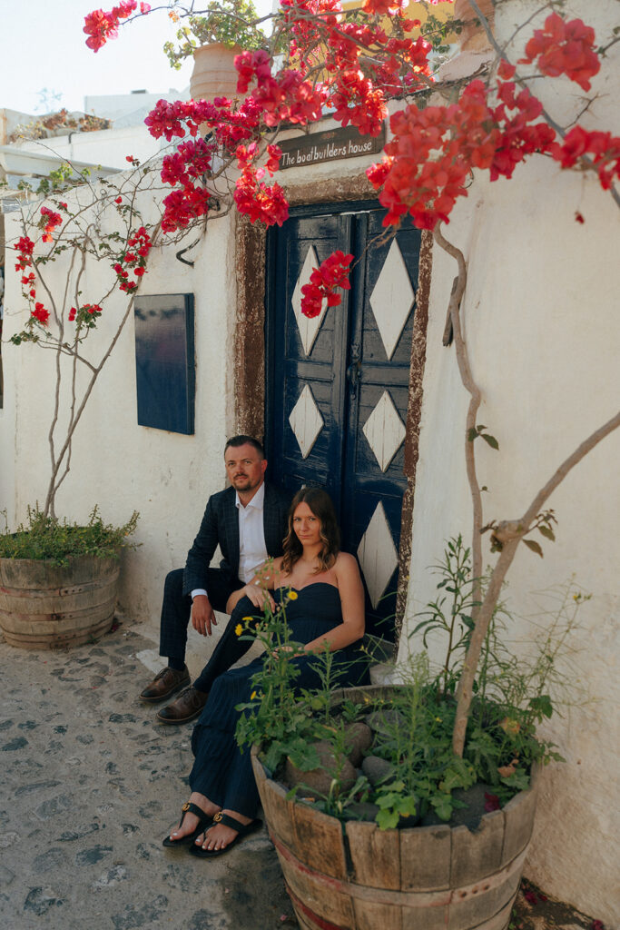 Couple kissing during golden hour maternity session in Oia Santorini with caldera views