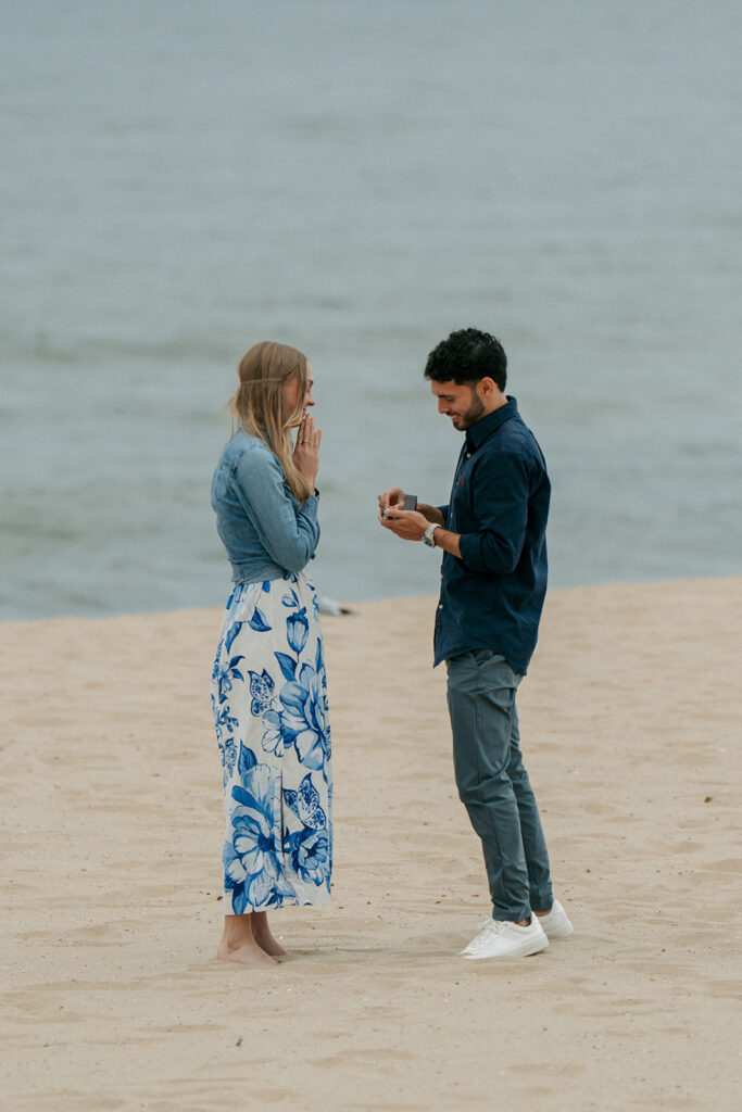 Couple kissing on Oval Beach with dramatic cloudy sky and Lake Michigan backdrop