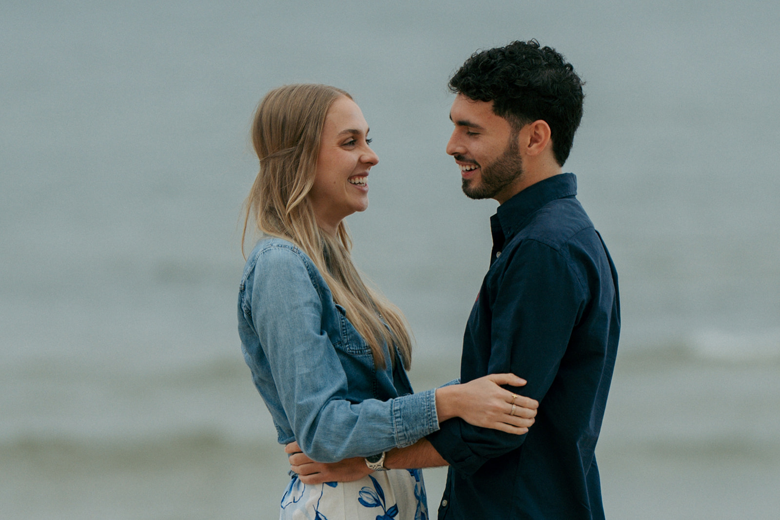 Couple walking through beach grass at Oval Beach during romantic engagement photos Michigan