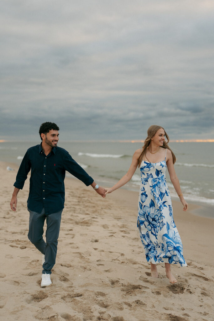 Bride-to-be showing engagement ring with Lake Michigan beach background in Saugatuck