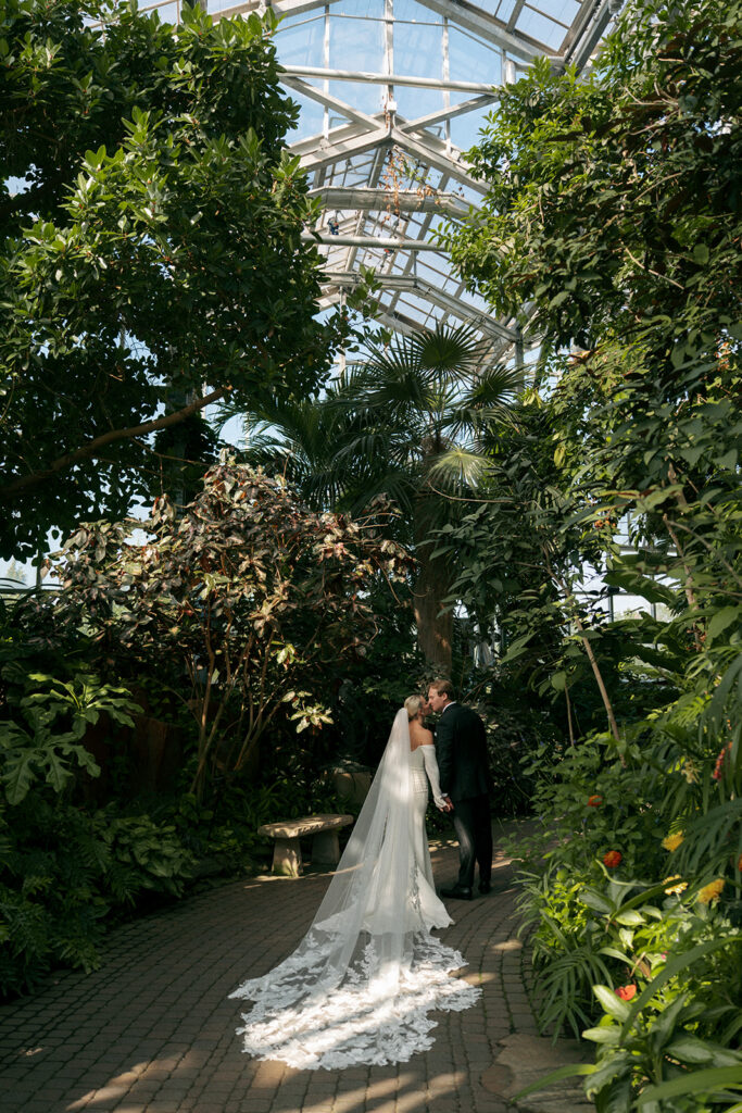 Bride and groom walking through lush gardens at Fredrick Meijer Gardens wedding in Grand Rapids Michigan
