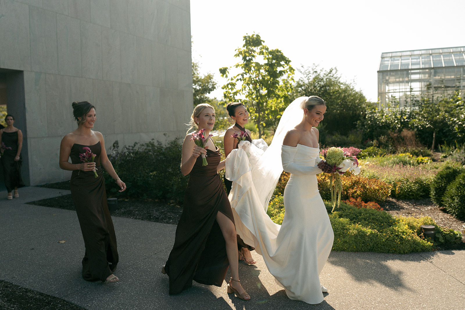 Bridal party laughing together in lush garden setting at Fredrick Meijer Gardens wedding
