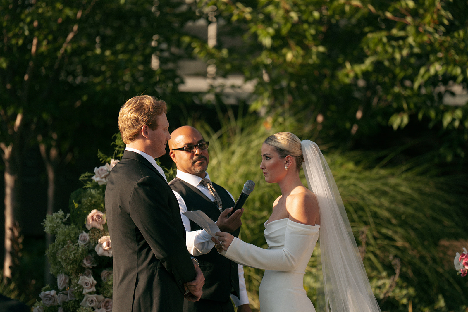 Bride and groom exchanging vows during outdoor ceremony at Fredrick Meijer Gardens