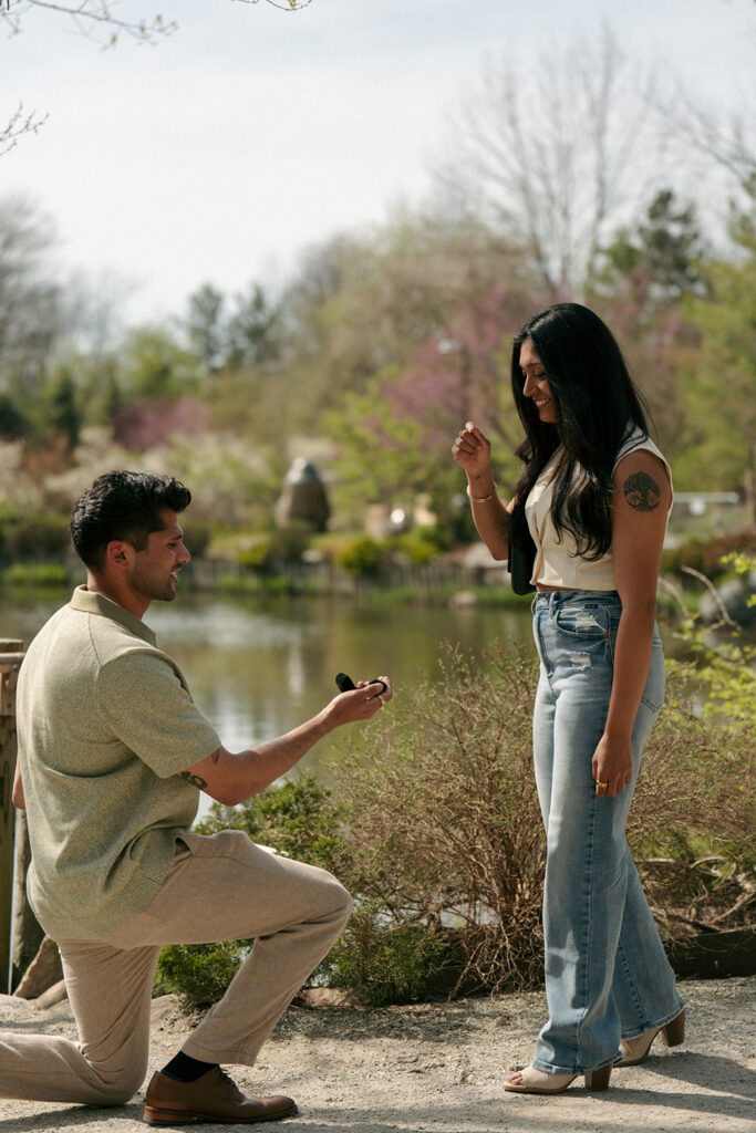 Couple kissing under blooming flowers Frederik Meijer Gardens engagement session
