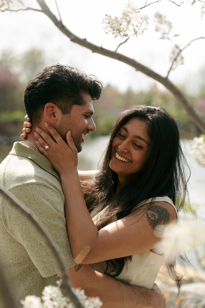 Couple laughing together during golden hour engagement photos at Meijer Gardens