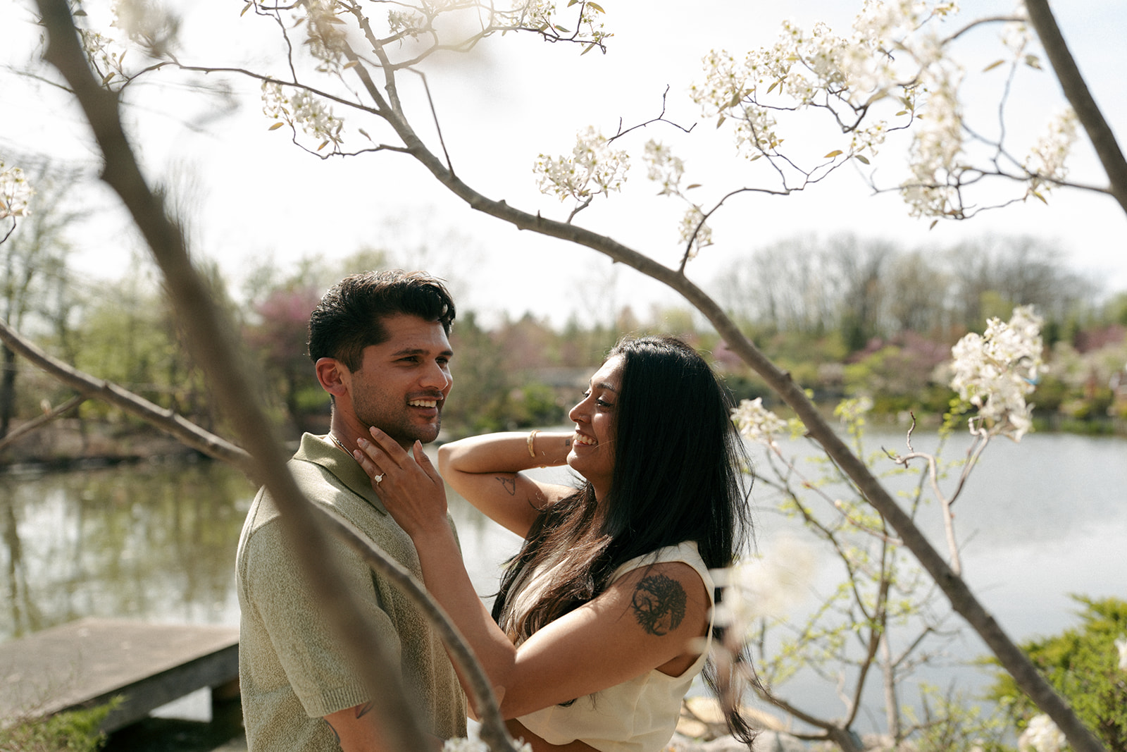 Romantic kiss under flowering trees at Frederik Meijer Gardens engagement session