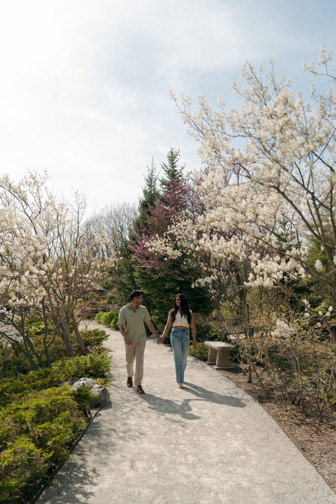 Couple walking hand in hand through sculpture garden at Meijer Gardens Grand Rapids
