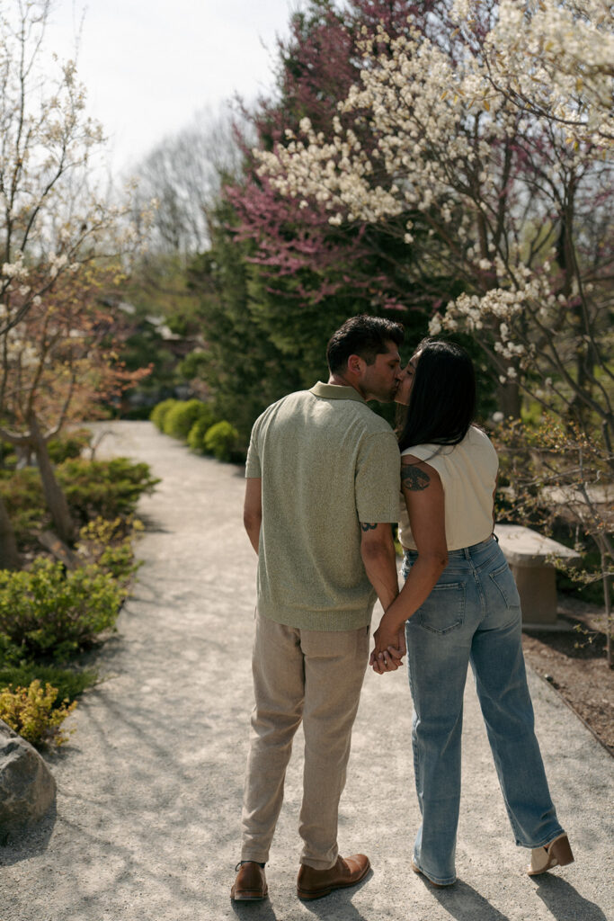 Couple sitting on garden bench surrounded by spring tulips Meijer Gardens engagement