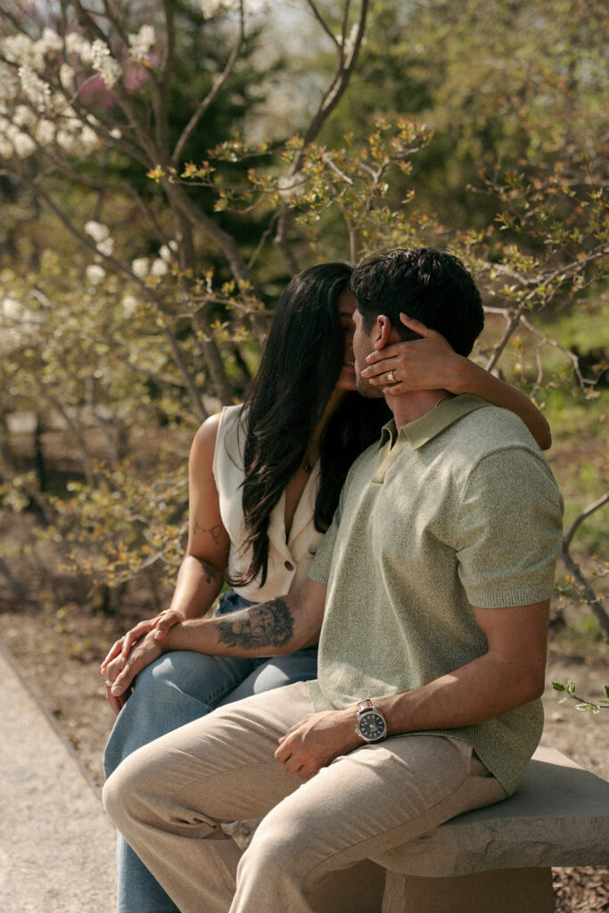 Couple kissing in tropical conservatory during engagement photos at Meijer Gardens