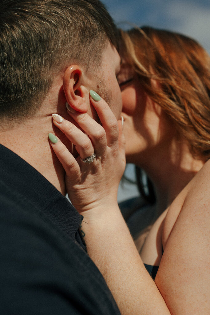 Couple embracing with windswept hair at cliffside Tantalon Castle overlooking sea