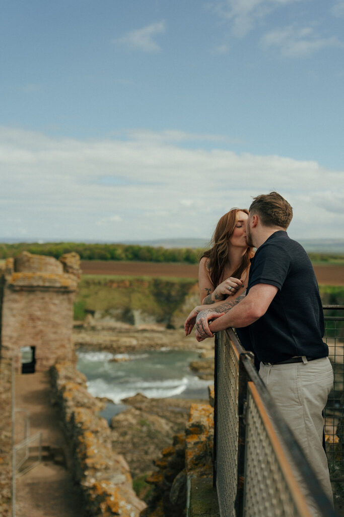 Engaged couple sitting together on ancient castle steps at Tantalon Scotland