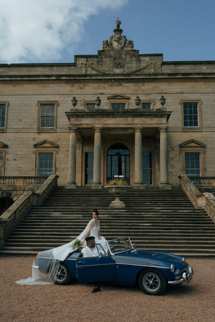 Bride in flowing wedding dress on grand staircase at historic Gosford House