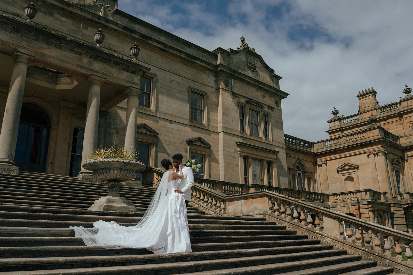 Wide shot of Gosford House exterior with rolling Scottish countryside at sunset