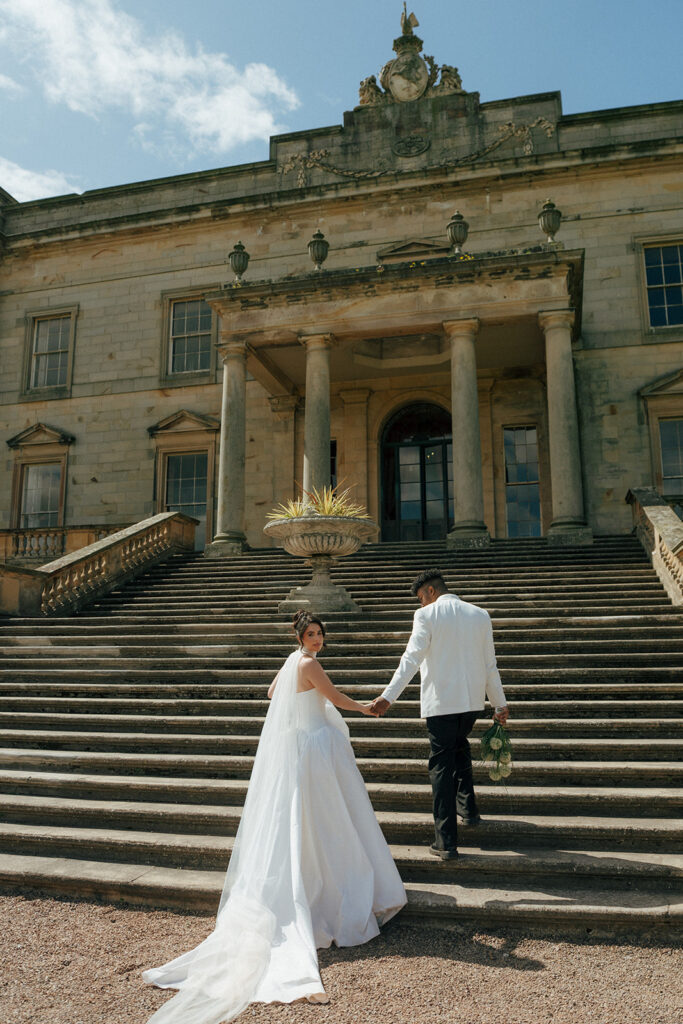 Bride and groom walking through Scottish countryside at Gosford House wedding