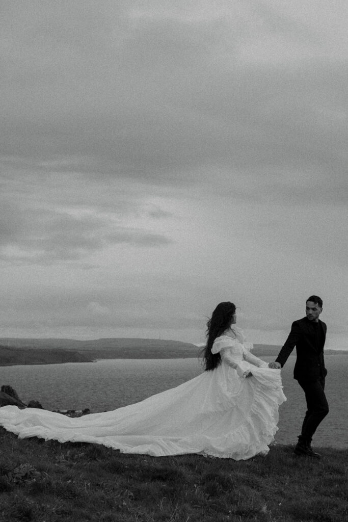 Couple reading vows during intimate cliffs elopement photos Fast Castle Edinburgh Scotland ceremony
