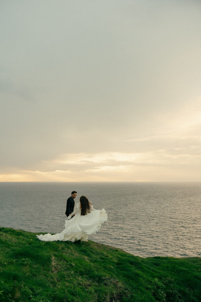 Groom looking at bride during cliffs elopement photos Fast Castle Edinburgh Scotland emotional moment