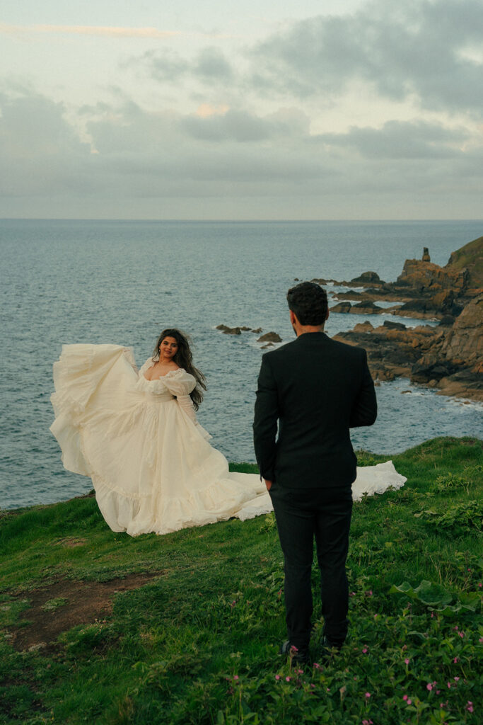 Couple sitting on cliff edge during cliffs elopement photos Fast Castle Edinburgh Scotland intimate moment
