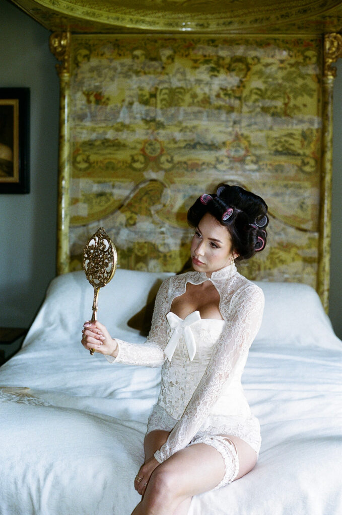 Bride in elegant white robe getting makeup applied in natural light at Gosford House Scotland
